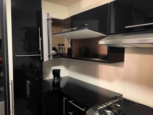 una pequeña cocina con armarios negros y fogones en New House / VIP / 1 Block to the Beach, en Ensenada