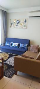 a living room with a blue couch in a room at Timur Bay Sea View & Pool View 2BR Family Suite in Kampung Saberang Balok