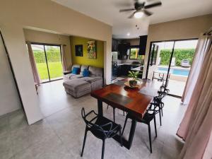 a living room with a wooden table and chairs at Volcano view house la Fortuna in Fortuna