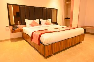 a bedroom with a large bed with a large headboard at Kalki Hotel in Port Blair