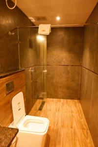 a bathroom with a toilet and a shower at Kalki Hotel in Port Blair