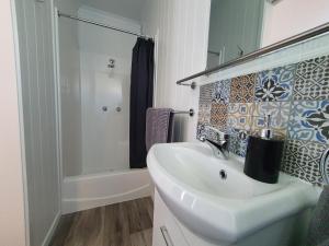 biała łazienka z umywalką i prysznicem w obiekcie Rose City Caravan Park w mieście Warwick