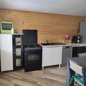 a kitchen with a stove and a refrigerator at Maison chaleureuse avec parking gratuit sur place in Coulogne