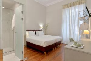 a hotel room with a bed and a bathroom at 1900 ATHENIAN HOUSE in Athens
