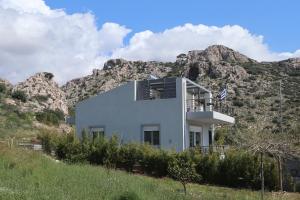 a house on a hill with mountains in the background at Patroclos SeaView in Sounio
