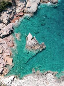Rocas Roja Beach Hotel Faralya في فاراليا: اطلالة جوية على تشكيل صخور في الماء