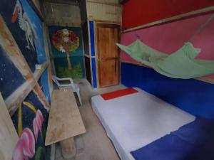 Habitación pequeña con cama y hamaca. en Hostal Camping Sin Fronteras Mompiche, en Mompiche