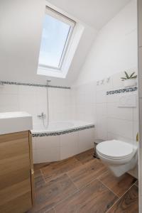 ein Bad mit einem WC, einem Waschbecken und einem Fenster in der Unterkunft Auszeit Natur in Villach
