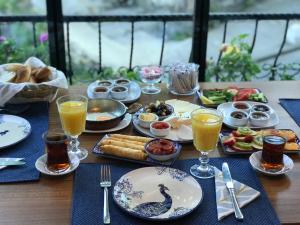 a table topped with plates of food and glasses of orange juice at Lonca Butik Hotel in Giresun