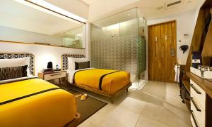 a hotel room with two beds and a television at Kosenda Hotel in Jakarta