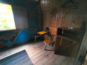 Habitación con escritorio, mesa y sillas. en Hostal Camping Sin Fronteras Mompiche en Mompiche