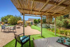 a patio with a table and chairs under a pergola at Can Torres in Pòrtol