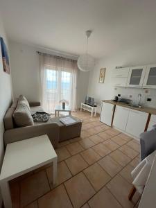 ein Wohnzimmer mit einem Sofa und einer Küche in der Unterkunft Apartment Frina II, Island Hvar in Jelsa