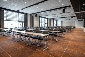 a classroom with tables and chairs in a room with windows at Quality Airport Hotel Værnes in Stjoerdal