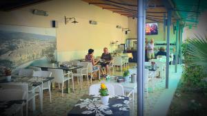 a group of people sitting at tables in a restaurant at Tropeacentro in Tropea