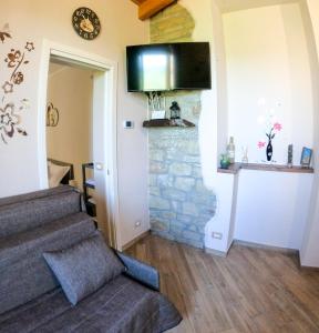 a living room with a stone fireplace and stairs at B&B L'Arenaria in Pietrapertosa