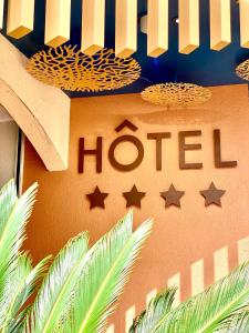 una señal para un hotel con estrellas en una pared en CAPAO Beach Hôtel, en Cap d'Agde