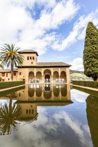 a building with a reflection in a pool of water at La Habitación del Arquitecto in Granada