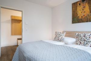 1 dormitorio con cama blanca y espejo en Stranddomizil 8, en Kellenhusen