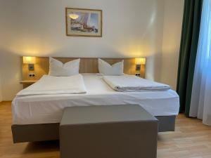 a bedroom with a large bed with white sheets and pillows at Hafner Hotel- Apartment in Stuttgart