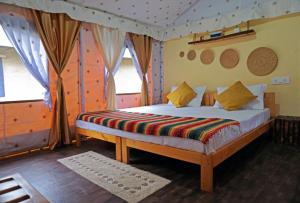 a bedroom with a bed in a room with windows at Crazy Cub Camp in Bīr