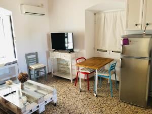a kitchen with a table and a refrigerator and chairs at LaLuzaki in Spetses