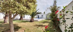 um jardim com árvores e uma piscina em Villa CLIMATISEE avec piscine privée, ras el ma em Tazagouin