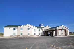 a large white building with a parking lot at Cobblestone Inn & Suites - Avoca in Avoca