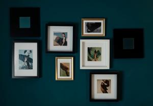 a group of framed pictures on a blue wall at Casa Tomà in Masera
