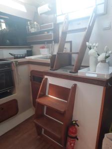 Voilier logement spacieux à louer au port - Gruissan Plage - 11 Aude في جرويسان: مطبخ مع كونتر مع كرسي خشبي ومغسلة