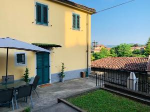 un patio con una mesa y una sombrilla y un edificio en Casa Luna - Private Cottage -Exclusive Private Garden, en Barga