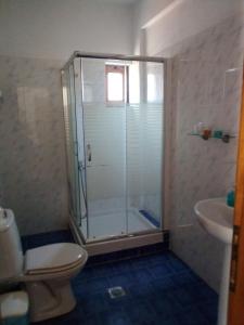 a bathroom with a shower and a toilet and a sink at Therisso Rooms in Thérison