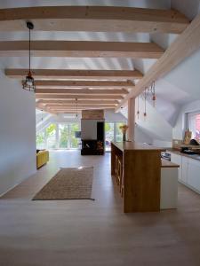 uma cozinha com tectos de madeira e uma grande ilha de cozinha em Apartamenty Odlot em Szczyrk