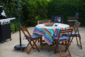 a table with a colorful table cloth and chairs and a stove at Elendar Morpeth Circa 1890 in Morpeth