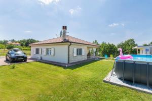 a house with a swimming pool and a pink flamingo at Guest house Casa Dia in Labin