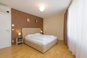 a bedroom with a white bed and a brown wall at Vienna Stay Apartments Linzerstrasse in Vienna