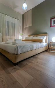 a large bed in a bedroom with a wooden floor at The Beetle House in Volos