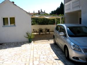a car parked in front of a house at Apartments Piacun in Sućuraj
