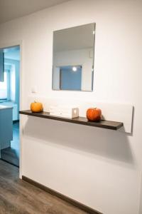 a bathroom with a mirror and two pumpkins on a counter at Ferienwohnungen Finkengrund in Büren