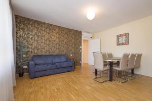 een woonkamer met een bank en een tafel en stoelen bij Vienna Stay Apartments Linzerstrasse in Wenen