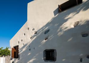 a white building with windows on the side of it at Kefali Villa, eco tourism experience, By ThinkVilla in Atsipádhes