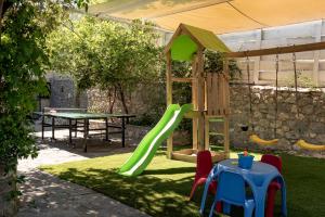 a playground with a slide and a table at Kefali Villa, eco tourism experience, By ThinkVilla in Atsipádhes