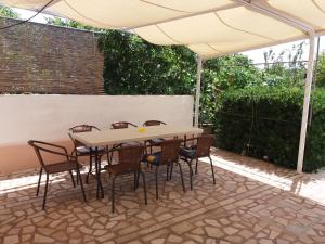 - une table et des chaises sous un parasol sur la terrasse dans l'établissement Apartments Piacun, à Sućuraj