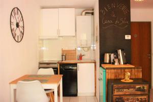 een kleine keuken met een tafel en een zwarte koelkast bij Appartement cozy aux Beaux Arts - Casa La Selva in Montpellier