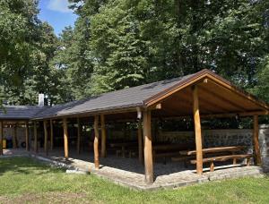 a pavilion with tables and benches in a park at Hotel Biele Studničky Dargov in Dargov