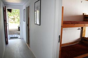 HøjbyにあるCabin for 16 people - Ejnersboの廊下、二段ベッドとドア付きの部屋