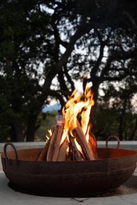 un pozo de fuego con llamas en él con un árbol en el fondo en Kruger River Lodge, en Hoedspruit