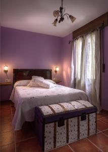a bedroom with a large bed with purple walls at Paloma in Ansó