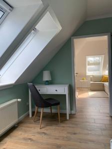 a attic room with a desk and a window at Sonniges Stadt-Apartment in ruhiger Parklage in Bad Segeberg