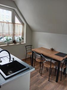 a kitchen and dining room with a table and a sink at Pensjonat Mickiewicz in Sandomierz